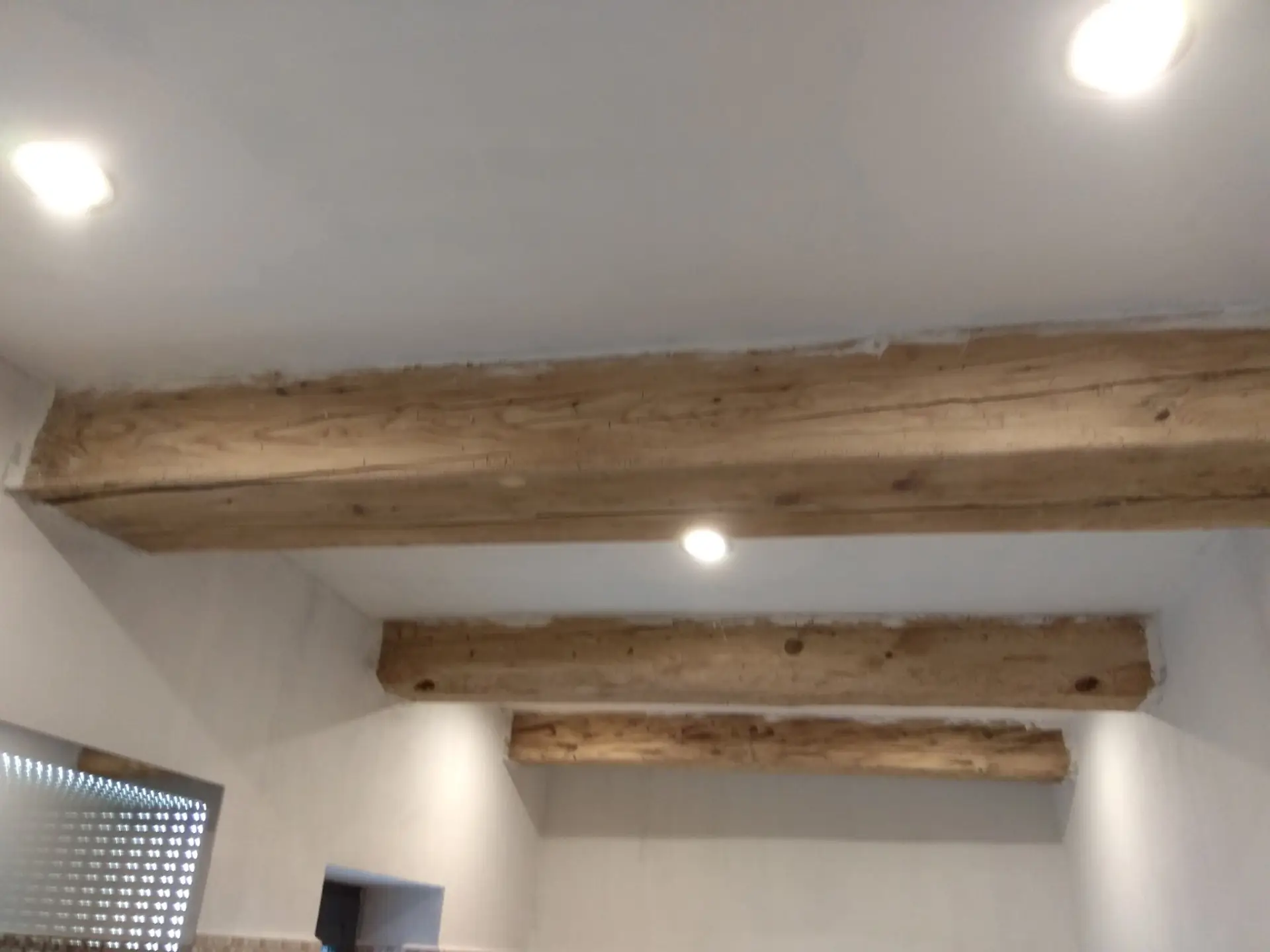 Stropní bodové osvětlení mezi dřevěnými trámy