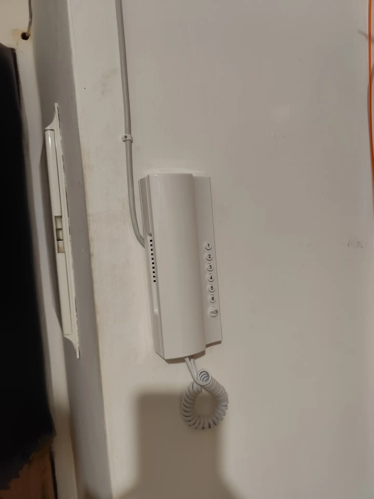 Klasický nástěnný domovní telefon v interiéru